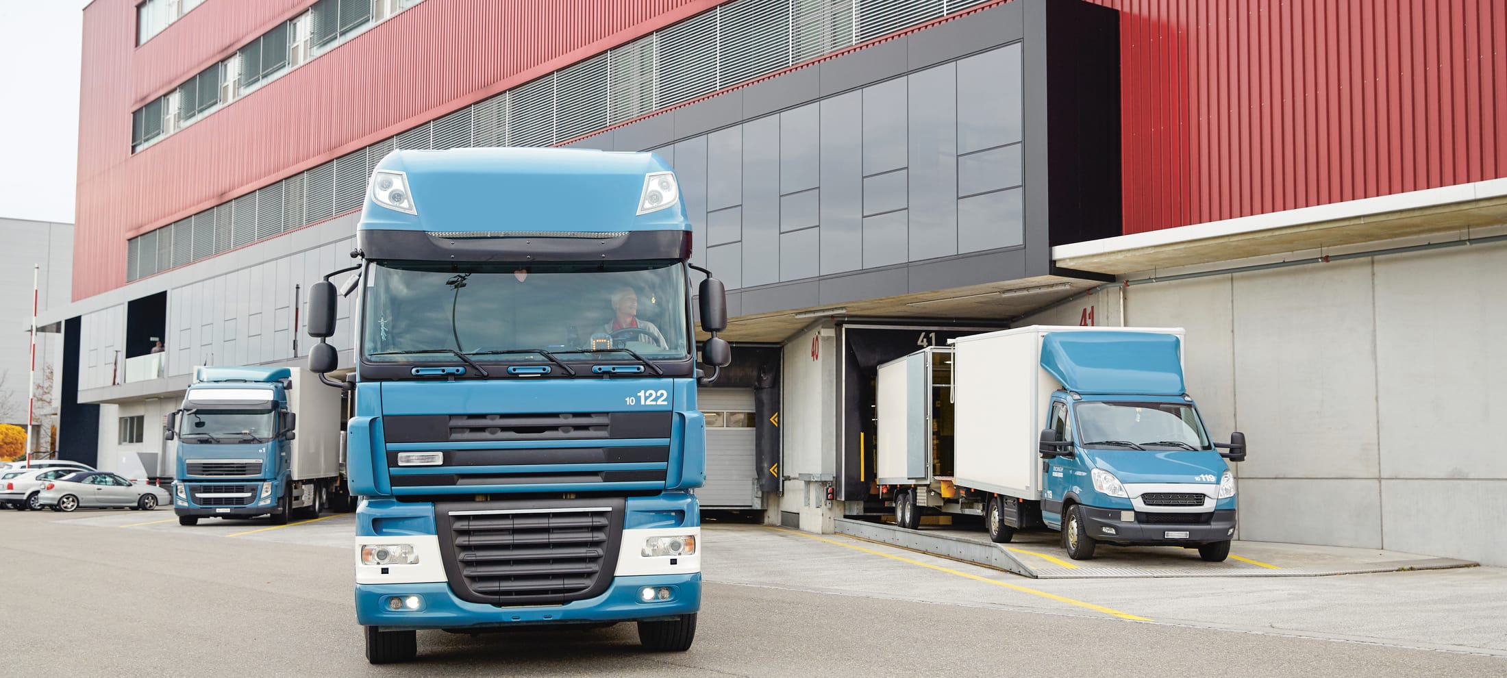 Türkisblauer Lastwagen verlässt ein Logistikzentrum 