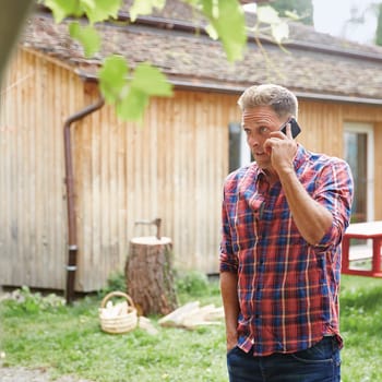 Protezione giuridica per privati: Uomo al telefono davanti a un albero abbattuto in giardino