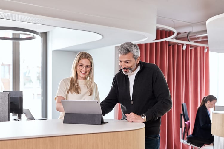 Due collaboratori della Protekta si scambiano informazioni davanti a un laptop