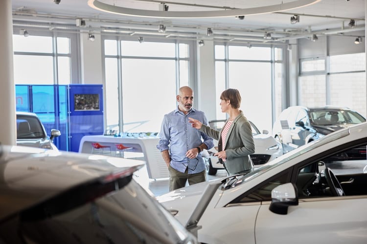 Zwei Personen diskutieren in einem Autofachgeschäft