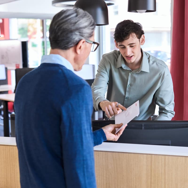 Un client remet une lettre à un guichet